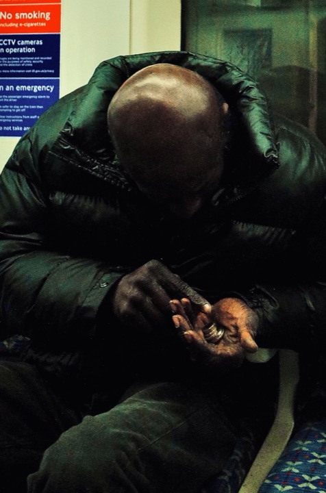 A seated traveller resting with their head bowed.